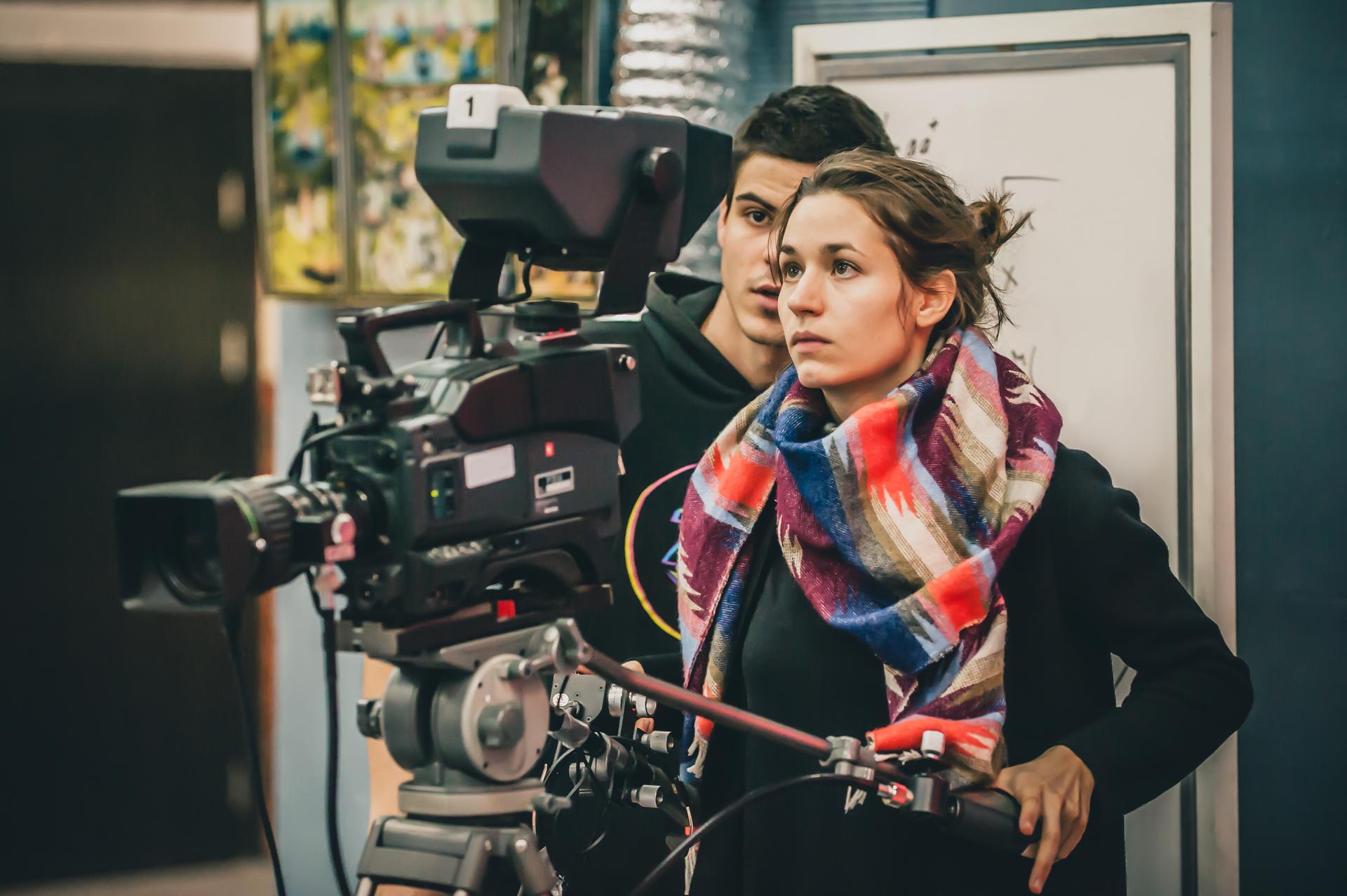 Behind the scene. Cameraman and assistant shooting film with camera